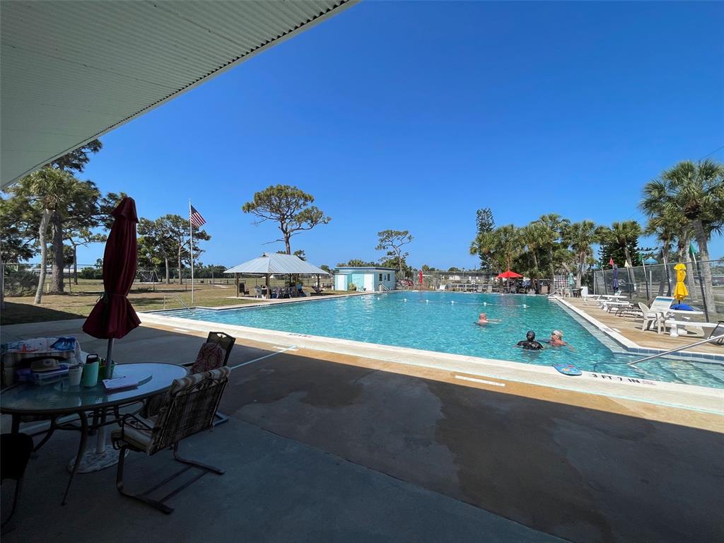 1350 Lakeside Drive Venice, FL 34293 - Photo 61 of 64 a view of a swimming pool with outdoor seating and plants