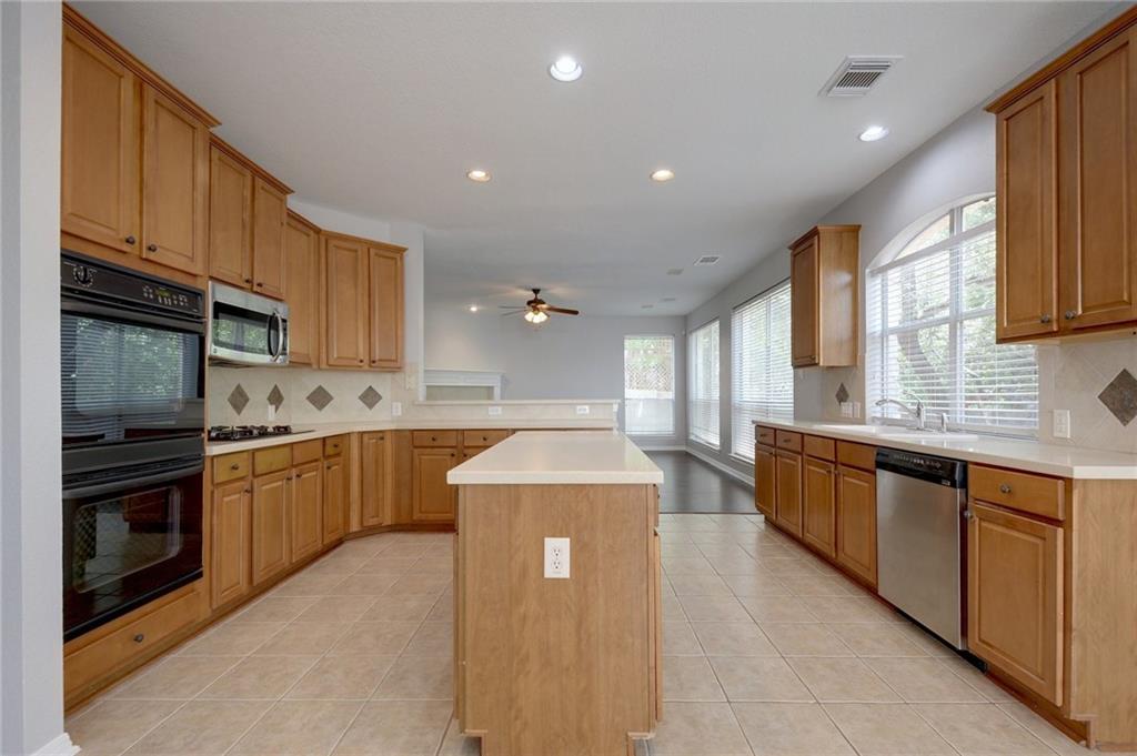 13017 Titus Court Austin, TX 78732 - Photo 13 of 26 Kitchen featuring tasteful backsplash, black appliances, light countertops, and recessed lighting