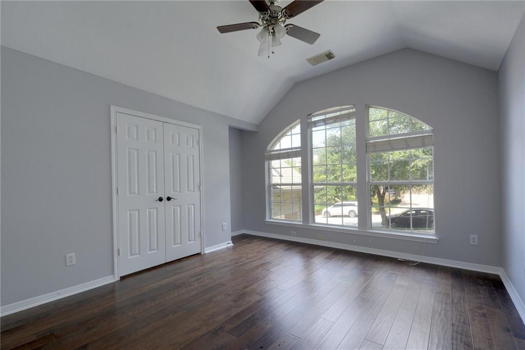 13017 Titus Court Austin, TX 78732 - Photo 17 of 26 Unfurnished bedroom featuring dark wood finished floors, a closet, lofted ceiling, and a ceiling fan