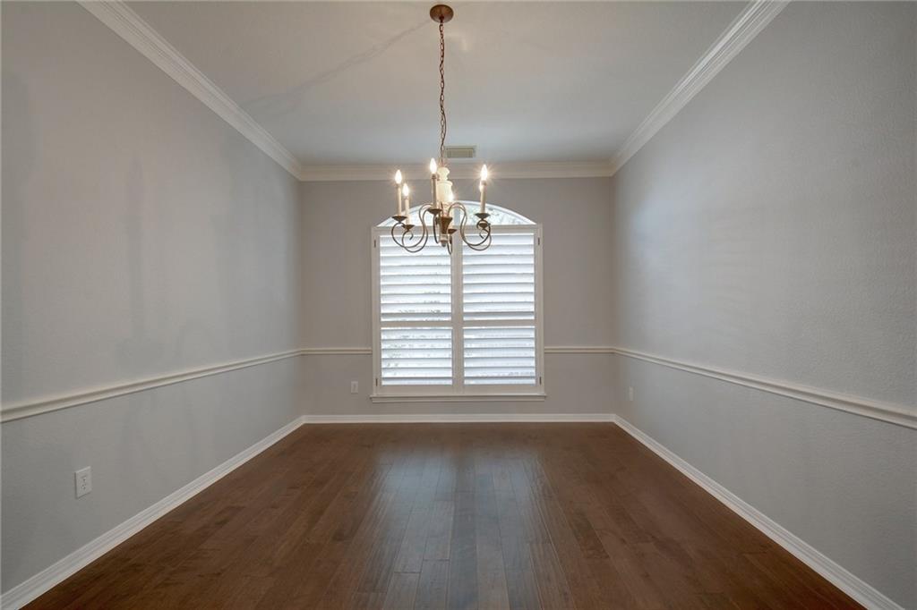 13017 Titus Court Austin, TX 78732 - Photo 8 of 26 Unfurnished dining area featuring a chandelier, dark wood finished floors, and ornamental molding