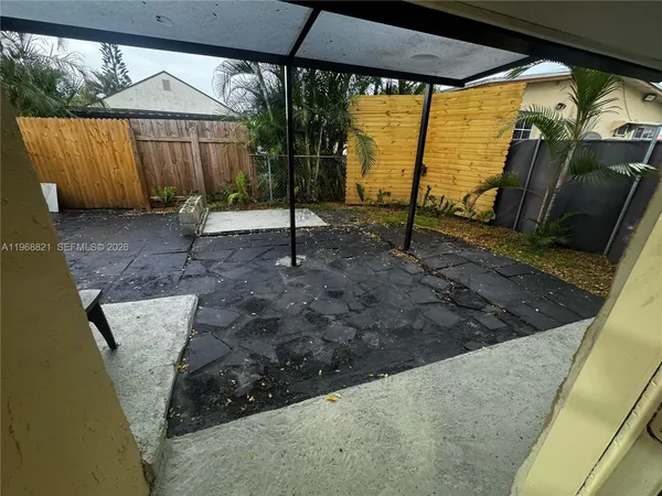 a view of a backyard with table and chair under an umbrella