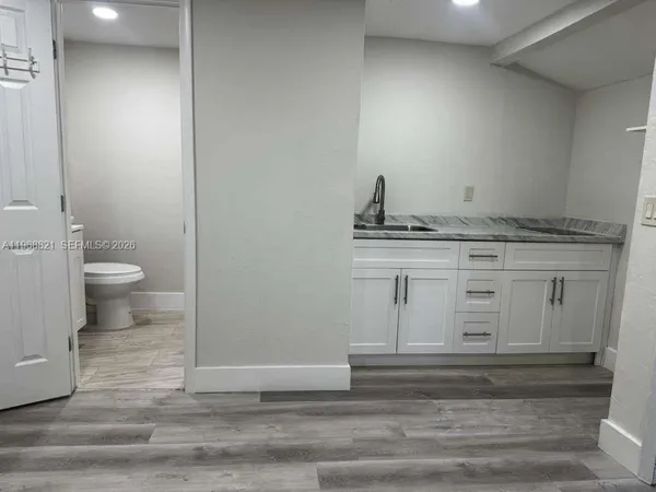 a bathroom with a granite countertop toilet and sink