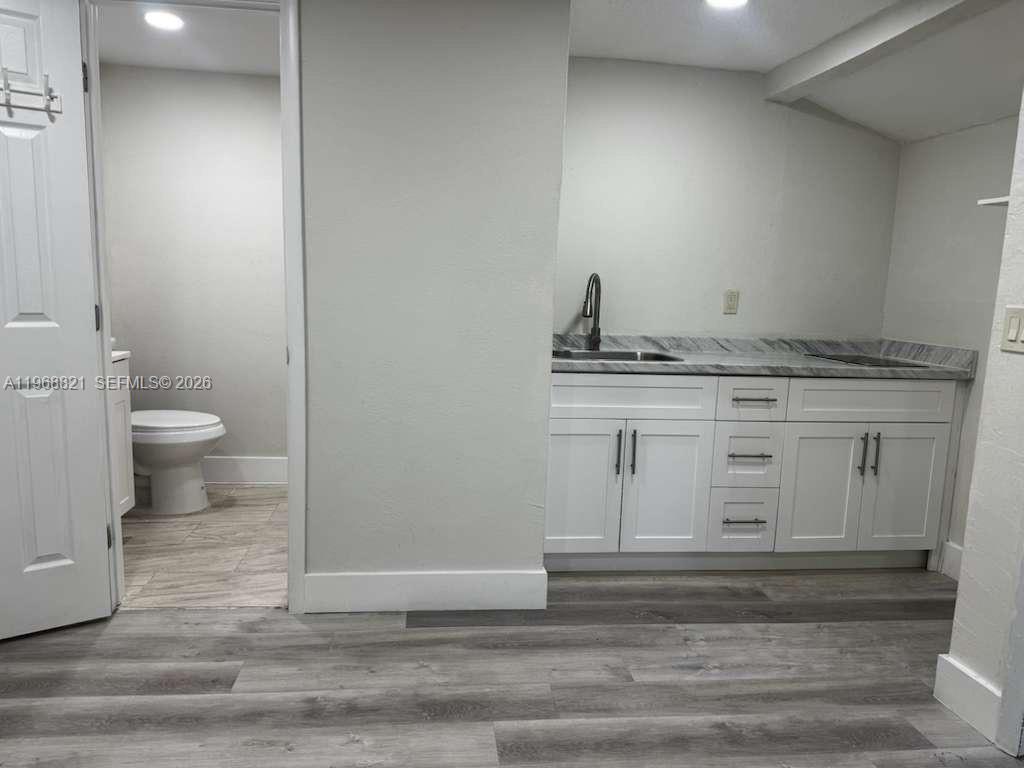 582 East 18th Street, Unit C Hialeah, FL 33013 - Photo 2 of 13 a bathroom with a granite countertop toilet and sink