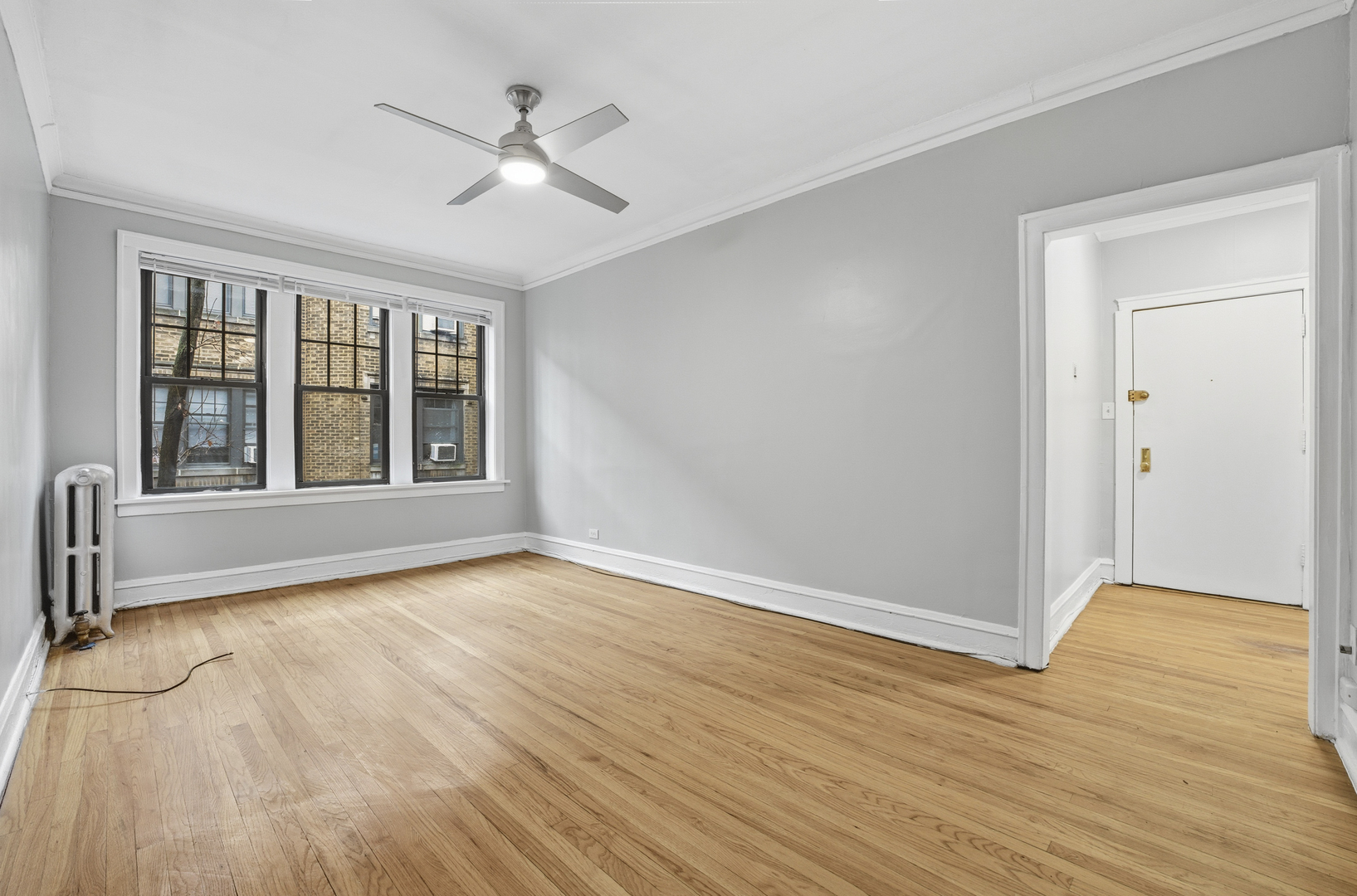 2336 West Addison Street, Unit I2 Chicago, IL 60618 - Photo 2 of 17 a view of an empty room with wooden floor and a window