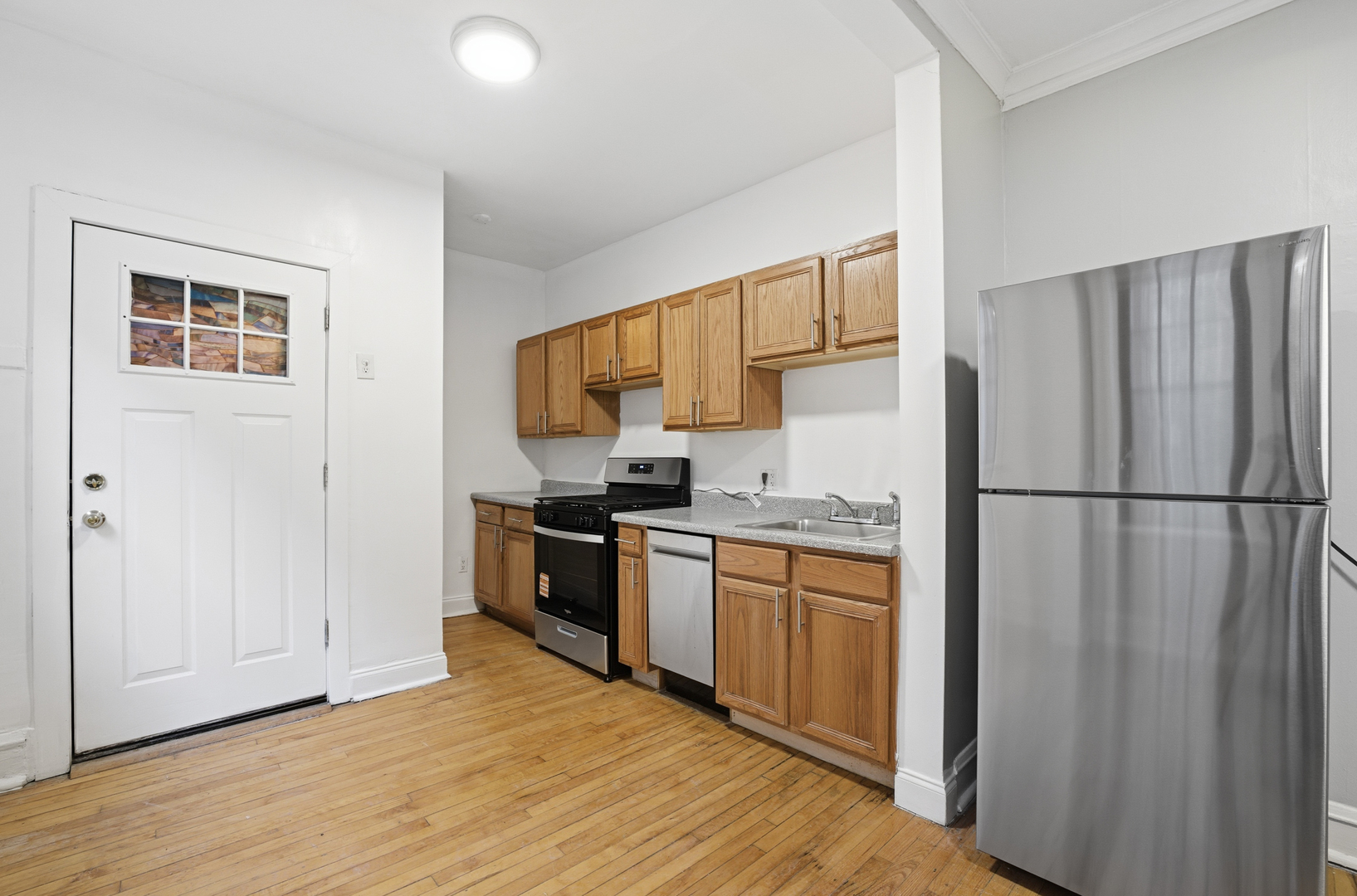 2336 West Addison Street, Unit I2 Chicago, IL 60618 - Photo 5 of 17 a kitchen with stainless steel appliances granite countertop a refrigerator stove top oven and sink