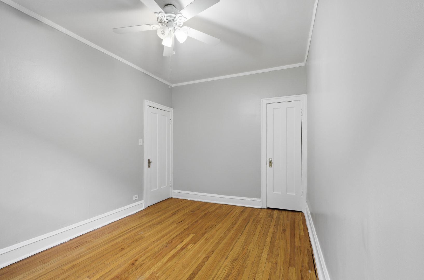 2336 West Addison Street, Unit I2 Chicago, IL 60618 - Photo 10 of 17 an empty room with wooden floor and fan