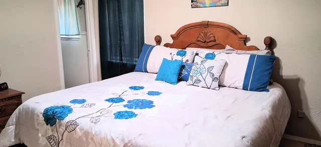 a bedroom with a bed and a wooden floor