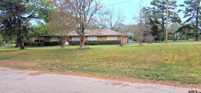 a view of a trees in front of a house with a big yard