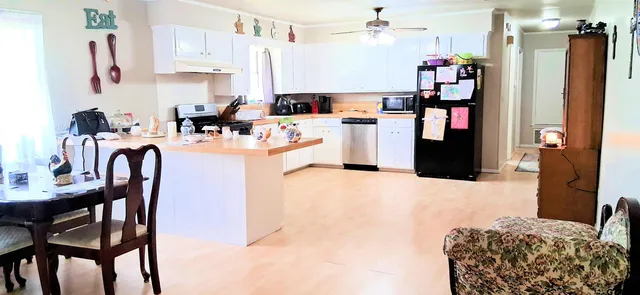 a kitchen with stainless steel appliances kitchen island granite countertop a refrigerator and microwave