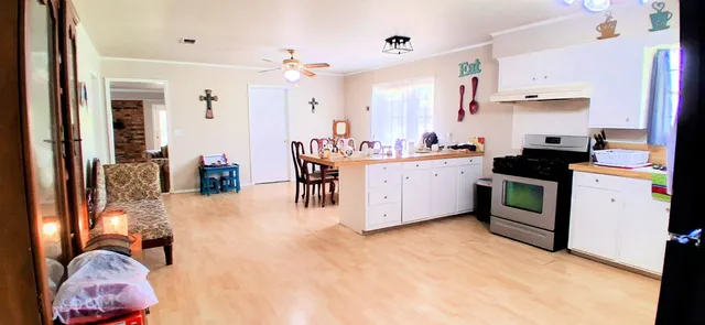 a kitchen with stainless steel appliances kitchen island granite countertop a stove and white cabinets