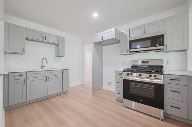 a kitchen with white cabinets stainless steel appliances and sink