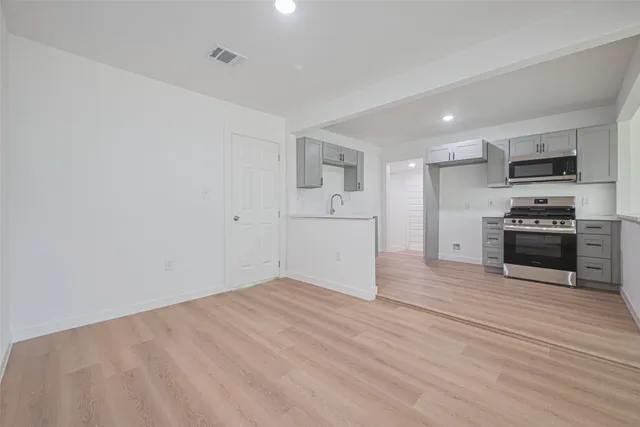 a view of a kitchen with wooden floor and electronic appliances