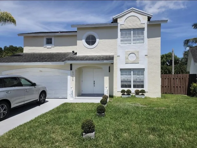a view of a house with a large window and a yard