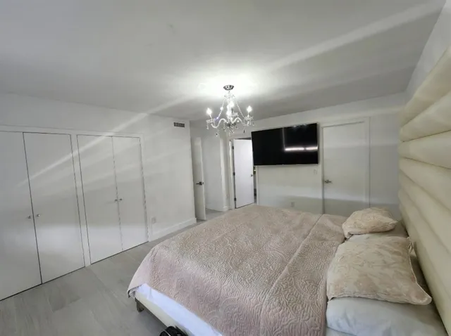 a bedroom with a bed and a chandelier