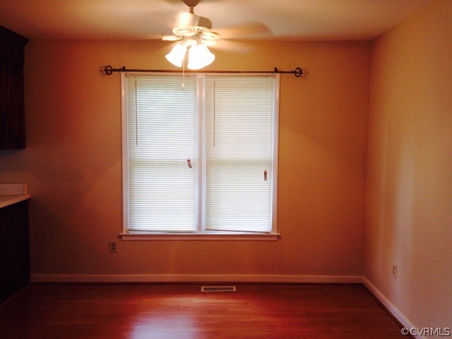 9303 Hunters Trail Road Petersburg, VA 23803 - Photo 3 of 7 an empty room with wooden floor and windows