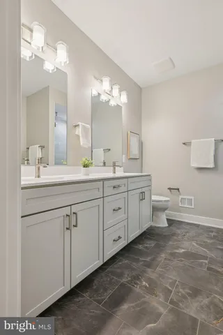 a spacious bathroom with a double vanity sink mirror and toilet