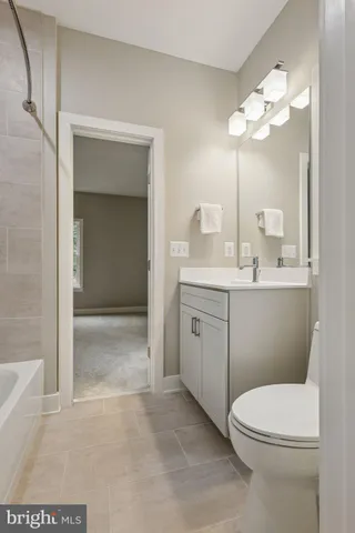 a bathroom with a toilet a sink a mirror and vanity