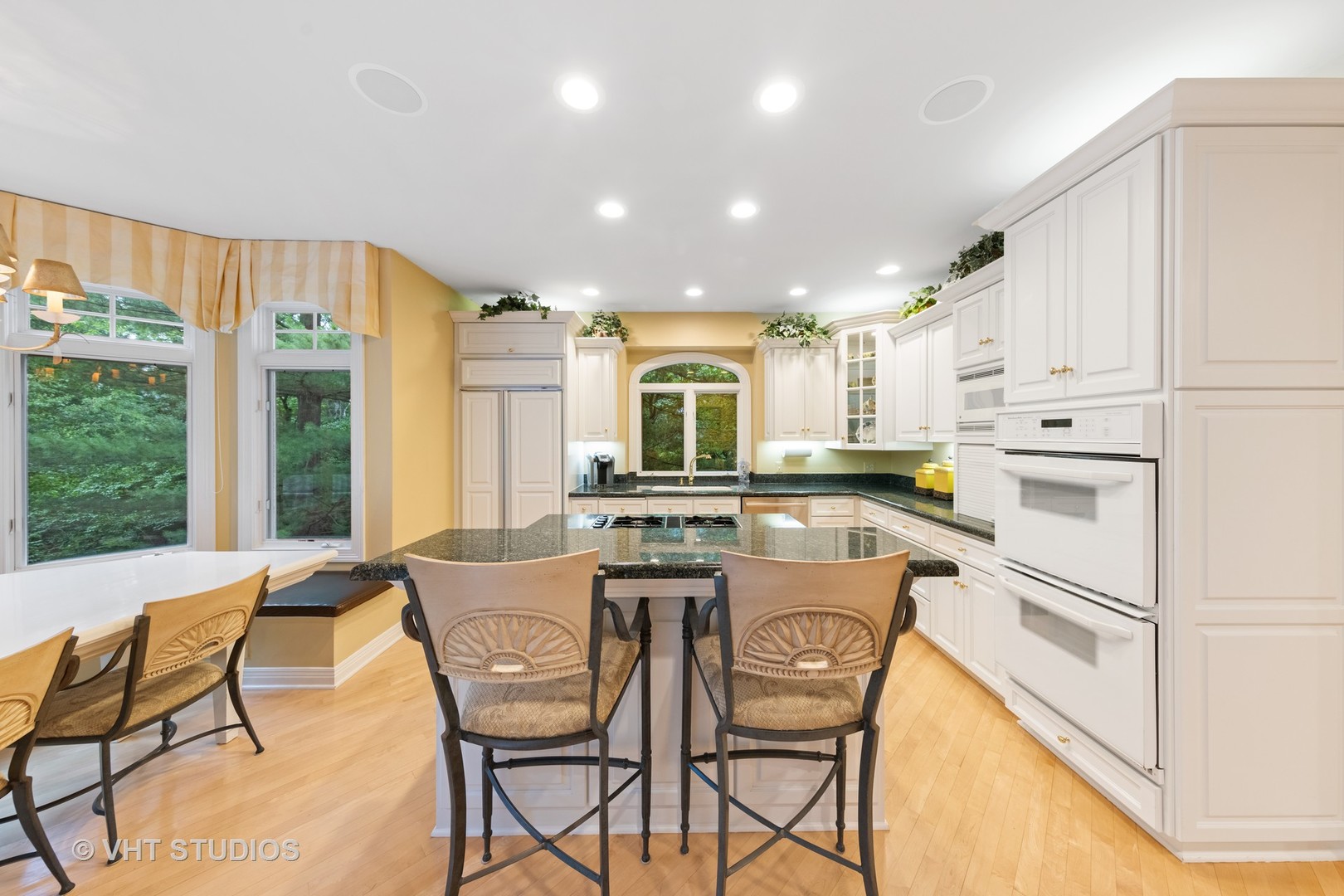 9301 Falling Waters Drive East Burr Ridge, IL 60527 - Photo 19 of 44 a kitchen with a dining table chairs and white cabinets