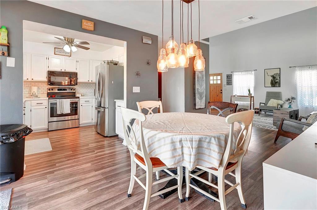 4211 Cindy Avenue Naples, FL 34112 - Photo 12 of 25 a view of a dining room with furniture window and wooden floor