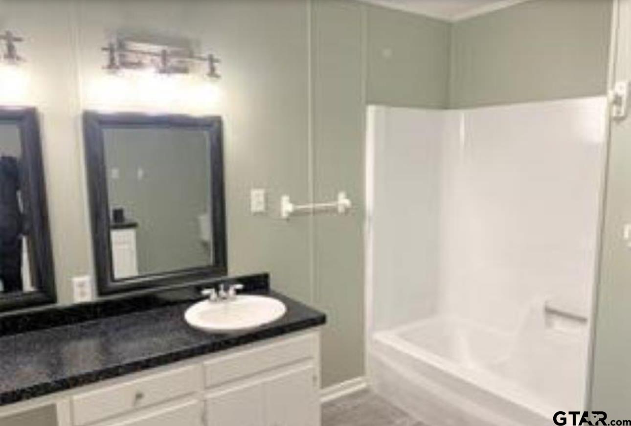 901 Cliff Street Quitman, TX 75783 - Photo 11 of 16 a bathroom with a sink and a mirror