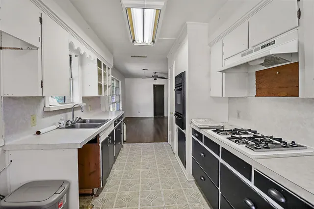 a kitchen with stainless steel appliances a sink stove and cabinets
