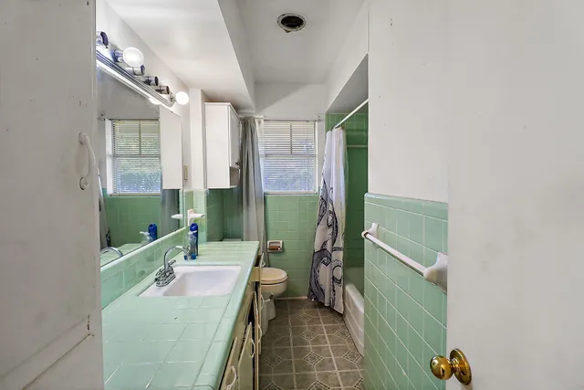 a bathroom with a mirror a sink and glass door
