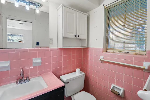 a bathroom with a sink a toilet and a mirror