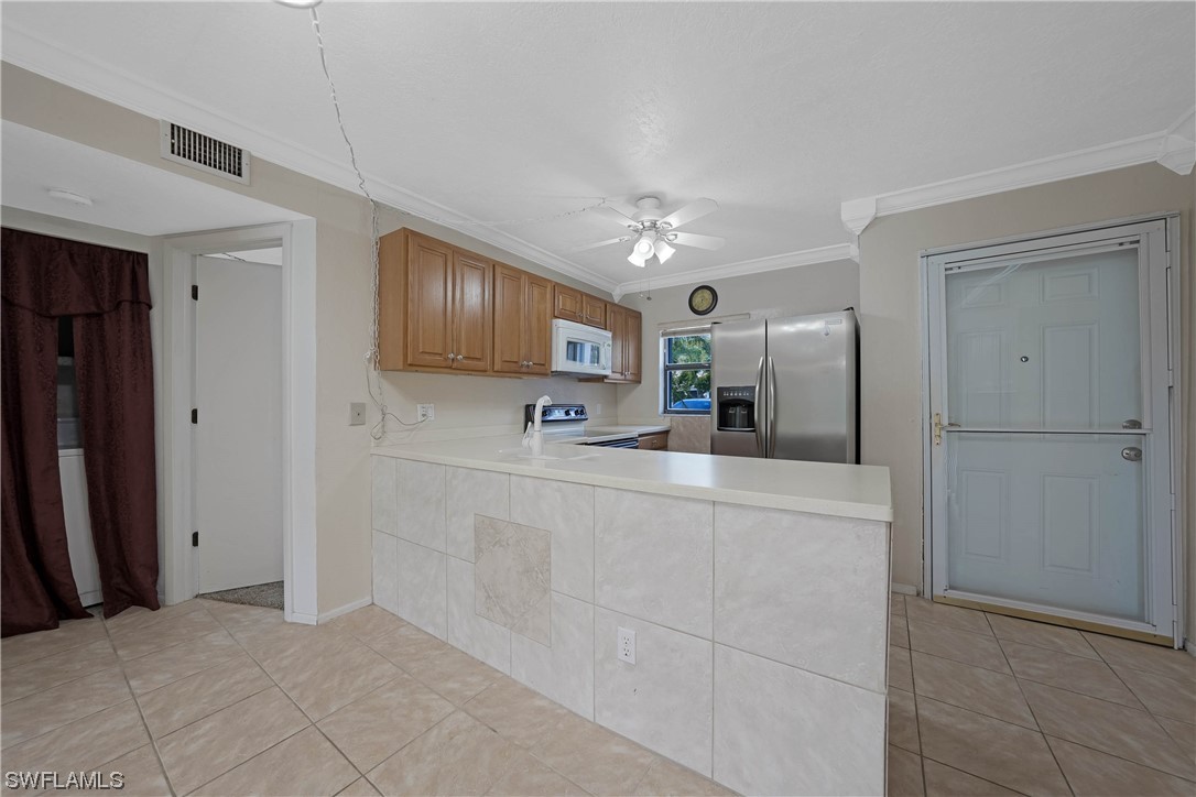 26485 Rampart Boulevard, Unit A6 Punta Gorda, FL 33983 - Photo 11 of 32 a kitchen with stainless steel appliances a refrigerator sink and cabinets