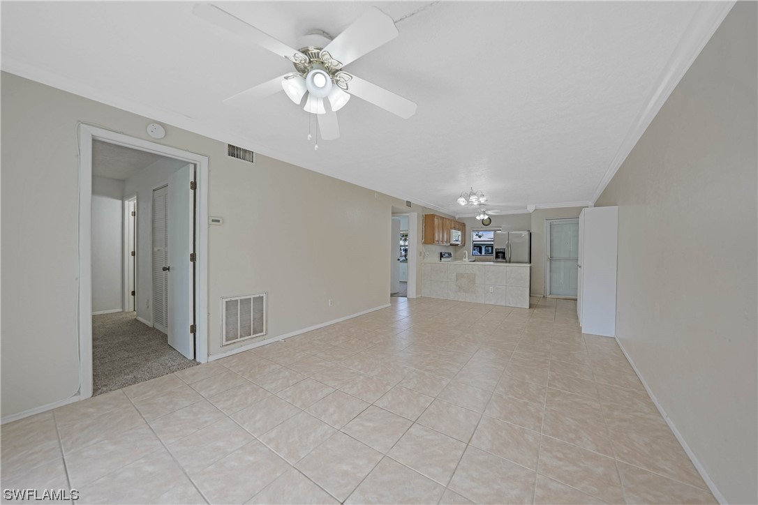 26485 Rampart Boulevard, Unit A6 Punta Gorda, FL 33983 - Photo 16 of 32 a view of a livingroom with a chandelier fan and kitchen view
