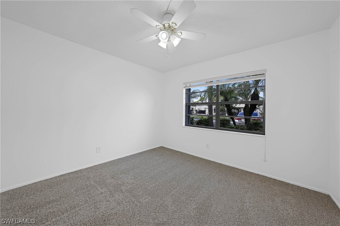 26485 Rampart Boulevard, Unit A6 Punta Gorda, FL 33983 - Photo 24 of 32 an empty room with a window and a ceiling fan