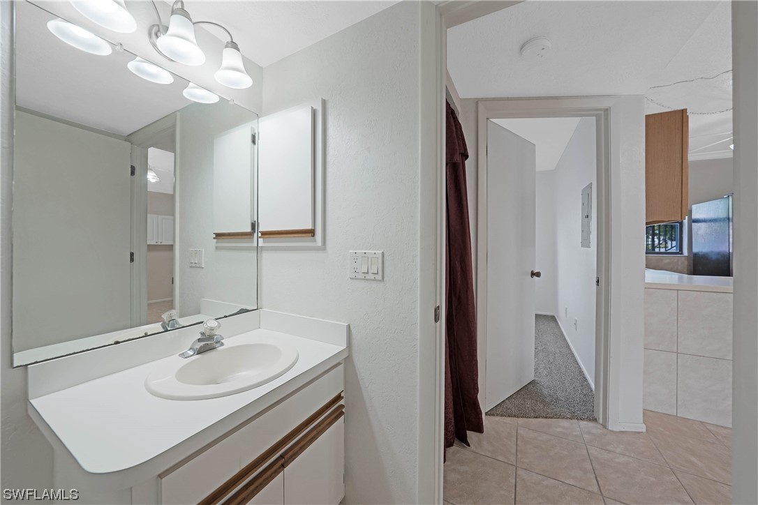 26485 Rampart Boulevard, Unit A6 Punta Gorda, FL 33983 - Photo 26 of 32 a bathroom with a sink a mirror and a shower