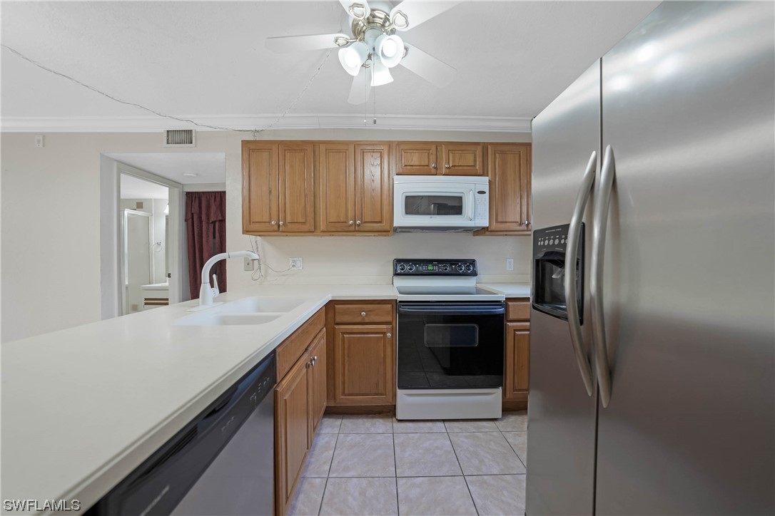 26485 Rampart Boulevard, Unit A6 Punta Gorda, FL 33983 - Photo 8 of 32 a kitchen with kitchen island granite countertop a stove sink and refrigerator