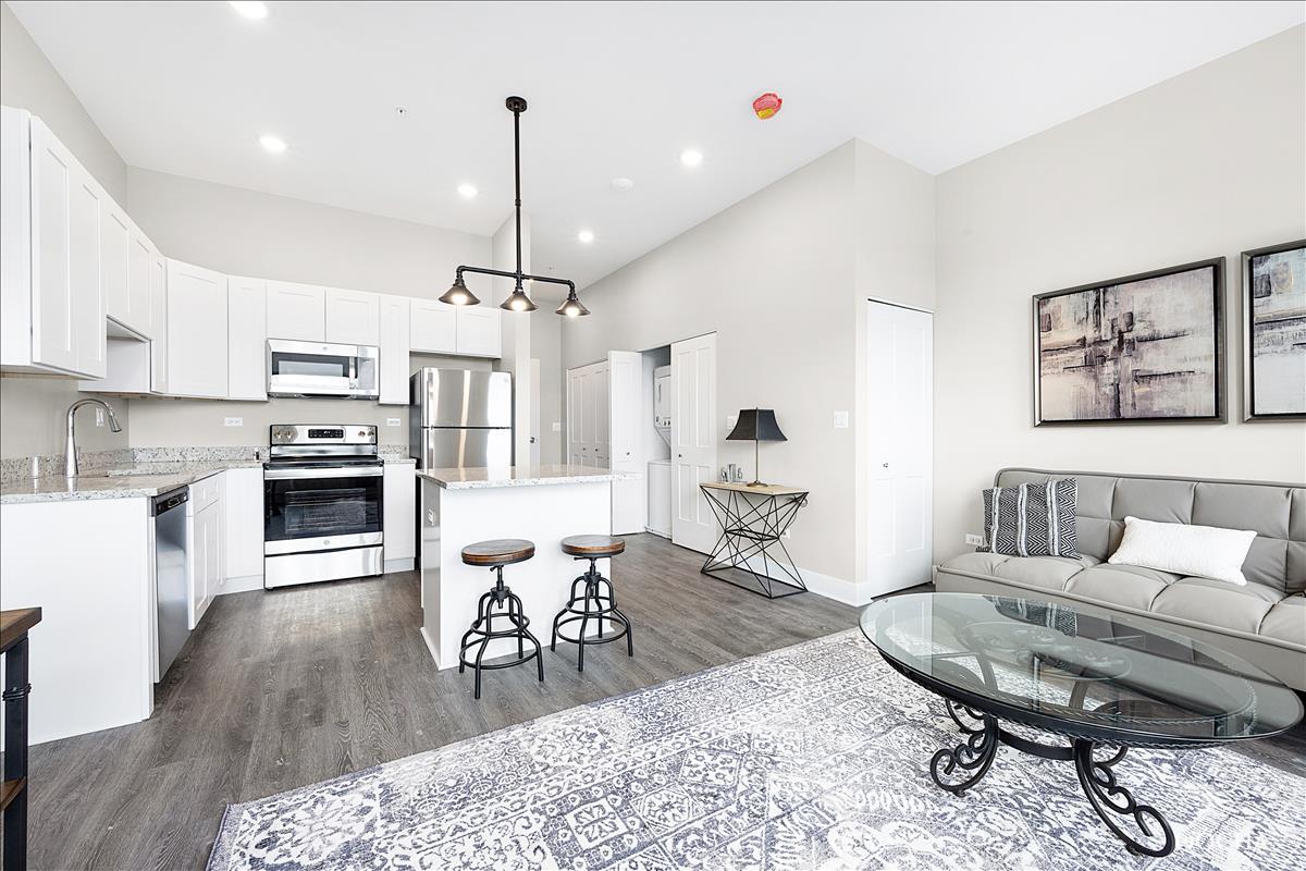 1101 Ritter Street, Unit 108 North Aurora, IL 60542 - Photo 2 of 14 a living room with furniture a dining table and a chandelier