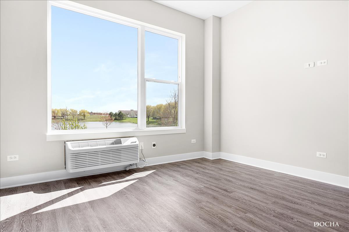 1101 Ritter Street, Unit 108 North Aurora, IL 60542 - Photo 10 of 14 a view of an empty room with wooden floor and a window
