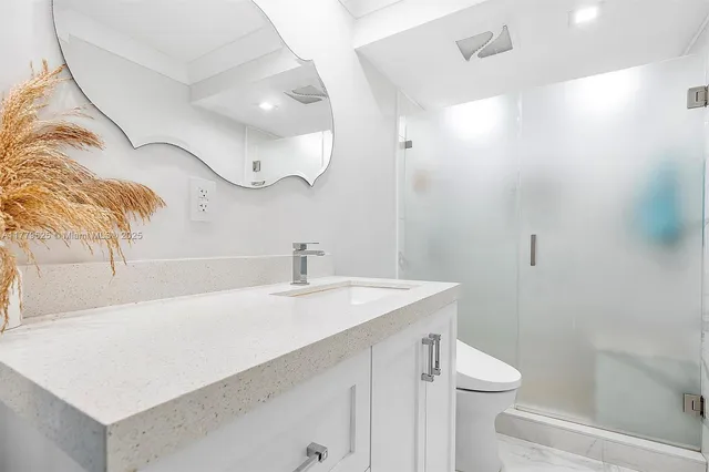 a bathroom with a sink a toilet and a mirror