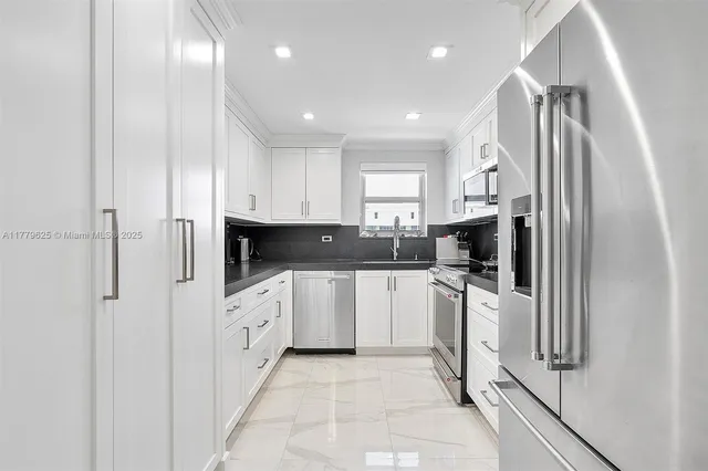 a kitchen with stainless steel appliances a refrigerator sink and microwave