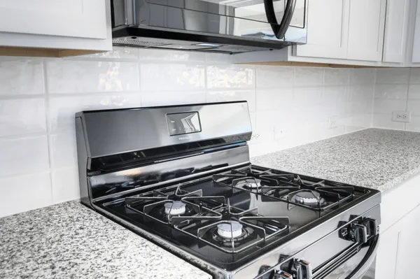 a stove top oven sitting inside of a kitchen