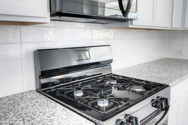 a stove top oven sitting inside of a kitchen
