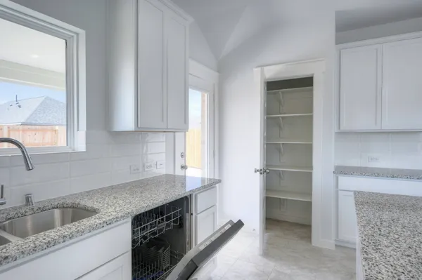 a kitchen with granite countertop a sink and cabinets