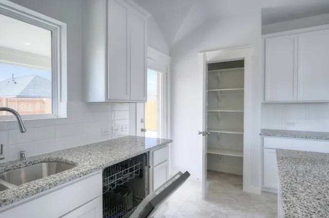 a kitchen with granite countertop a sink and cabinets