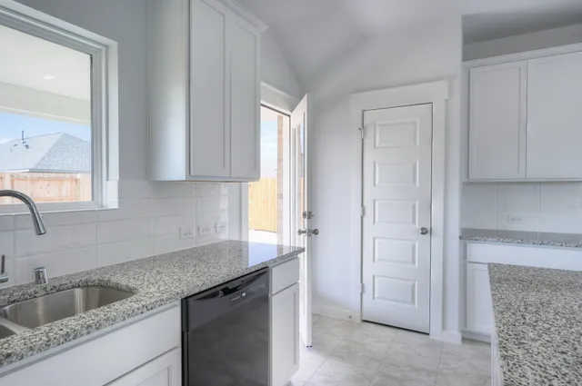 a kitchen with granite countertop a sink and cabinets