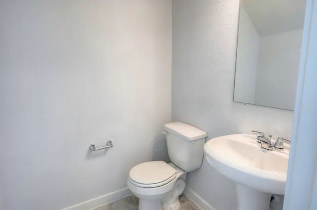 a white toilet sitting next to a bathroom sink