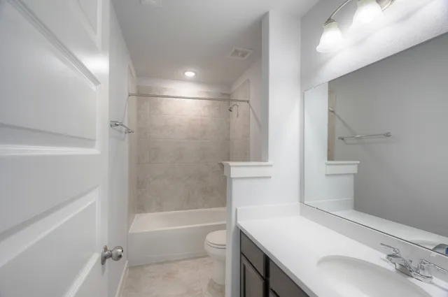 a bathroom with a sink toilet vanity and bathtub