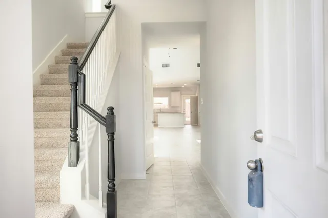 a view of a hallway with wooden floor and staircase