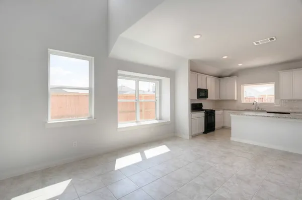 a open kitchen with white cabinets and white appliances