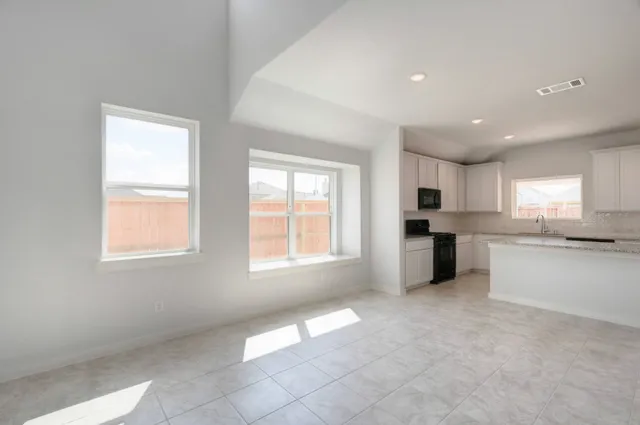 a open kitchen with white cabinets and white appliances