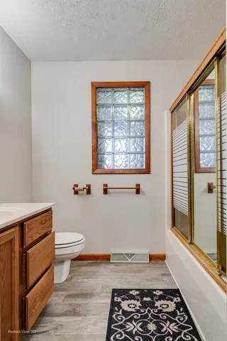 a bathroom with a toilet a sink and a window