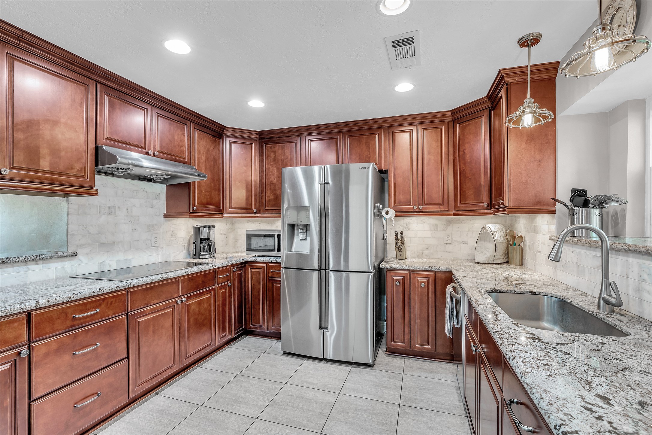18019 Shadow Valley Drive Spring, TX 77379 - Photo 12 of 48 The marble backsplash is a lovely accent to the cherry cabinets and stone counters and keeps the kitchen feeling fresh and classic