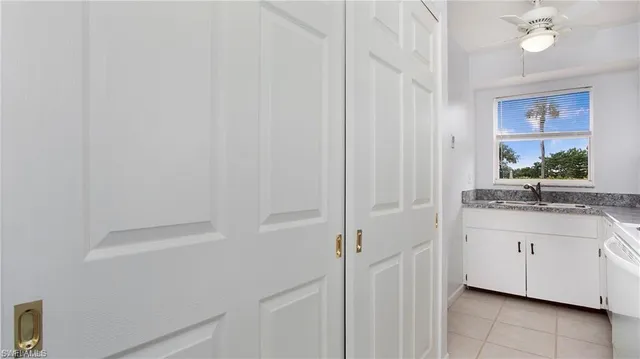a kitchen with granite countertop white cabinets and a sink