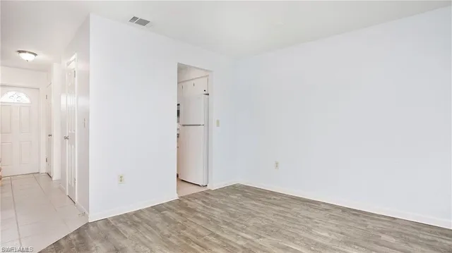 a view of empty room with wooden floor and ceiling fan